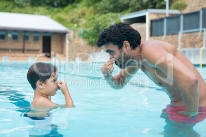 Father and son playing in pool