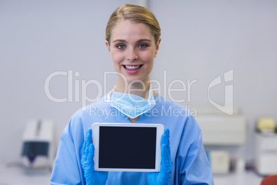 Portrait of smiling nurse holding digital tablet