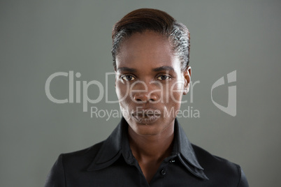 Androgynous man in black shirt posing against grey background