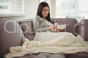 Woman using mobile phone while eating breakfast
