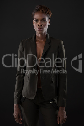 Androgynous man in suit posing against grey background