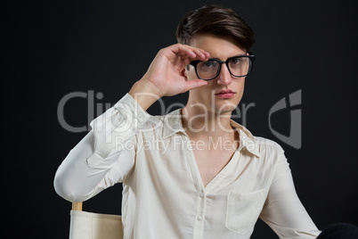 Androgynous man posing with spectacles