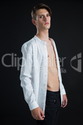 Androgynous man posing in open buttondown shirt