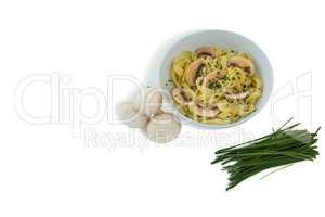 Pasta served in bowl by mushrooms and scallion