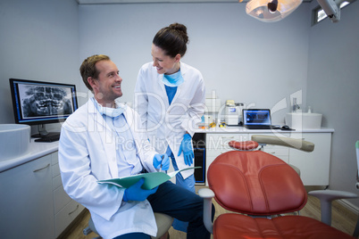 Dentists discussing on medical report in clinic