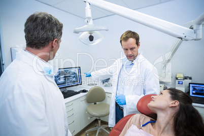 Dentists showing an x-ray of teeth to female patient