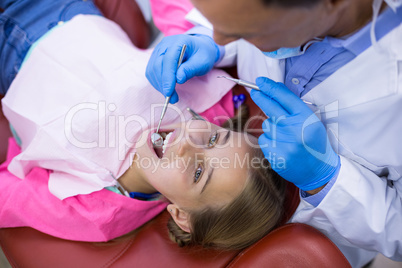 Dentist examining a young patient with tools