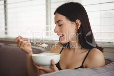 Smiling woman eating breakfast