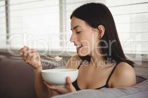 Smiling woman eating breakfast
