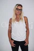 Beautiful transgender wearing eyeglasses standing against gray background