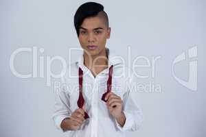 Portrait of confident transgender female holding red tie