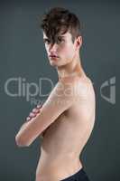 Shirtless androgynous man posing with arms crossed