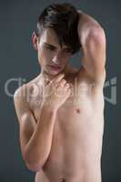 Shirtless androgynous man posing with hand on chin