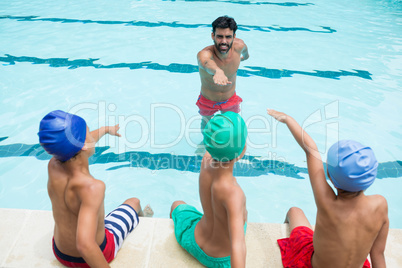Coach and students taking oath in swimming pool