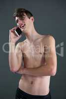 Shirtless androgynous man talking on mobile phone