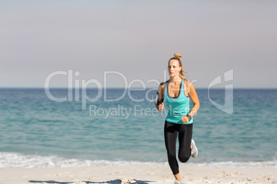 Young woman jogging on shore at beach