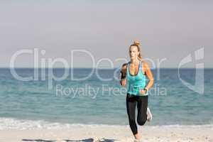 Young woman jogging on shore at beach