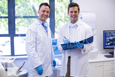 Portrait of happy dentists standing with file