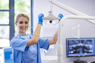 Portrait of female nurse adjusting dental light