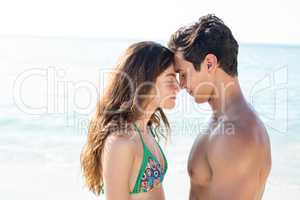 Couple standing face to face with eyes closed at beach