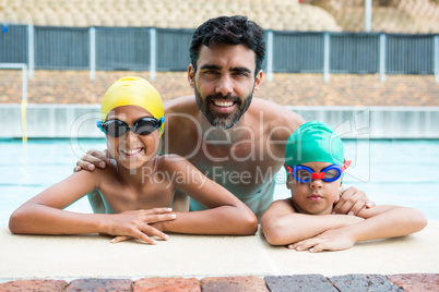 Father and kids smiling in the pool