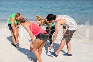 Friends exercising on shore at beach