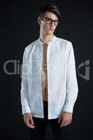 Androgynous man in spectacles posing in open buttondown shirt