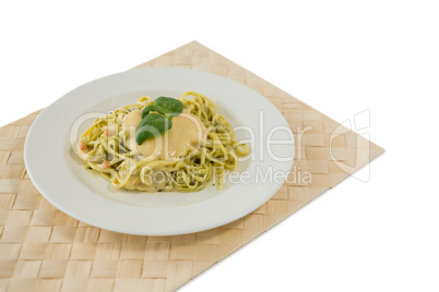 Close up of fettuccine served in plate on place mat