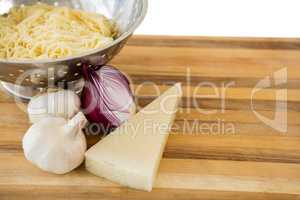 Close up of pasta in colander with ingredients on cutting board