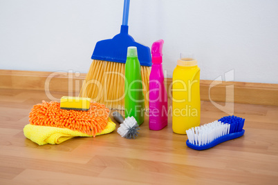 Chemical bottles by brush and sponges with broom on floor