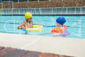 Two kids swimming in pool