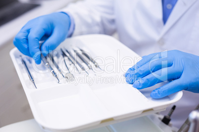 Dentist picking up dental tool