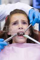 Dentists examining a young patient with tools