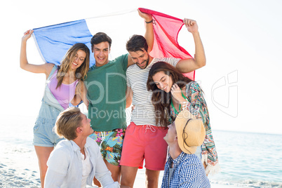 Happy friends holding French flag on shore