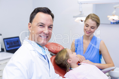 Dentist smiling at camera in dental clinic