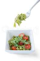 Pasta salad in bowl with fork against white background