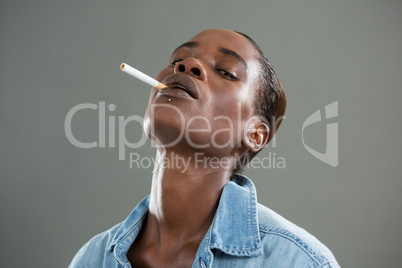 Androgynous man posing with cigarette in his mouth