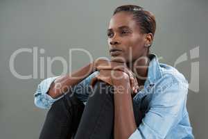 Androgynous man in denim shirt posing against grey background