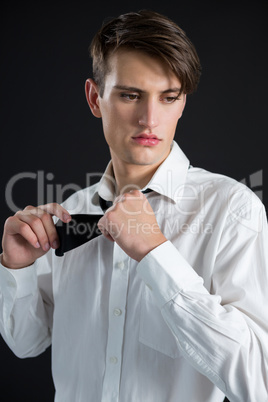 Androgynous man posing against black background