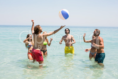 Friends playing with ball in sea
