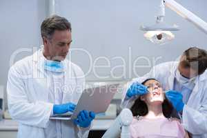 Dentist using laptop at dental clinic