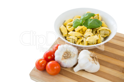 Close up of pasta served in bowl on cutting board