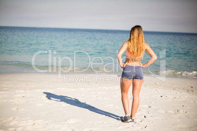 Woman standing with hands on hip at beach