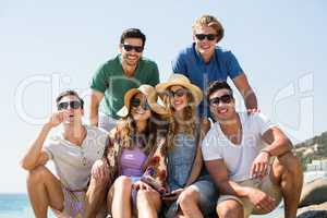 Young smiling friends against clear sky