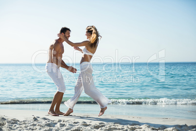 Side view of playful couple at beach