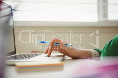 Close up of woman working on laptop at table