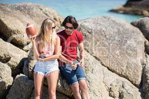 Couple talking while sitting on rock formation