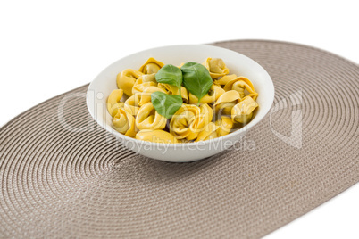 Close up of cooked pasta served in bowl on place mat