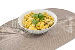 Close up of cooked pasta served in bowl on place mat