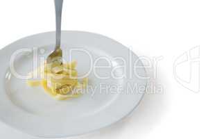 Spaghetti rolled up in fork with plate on white background